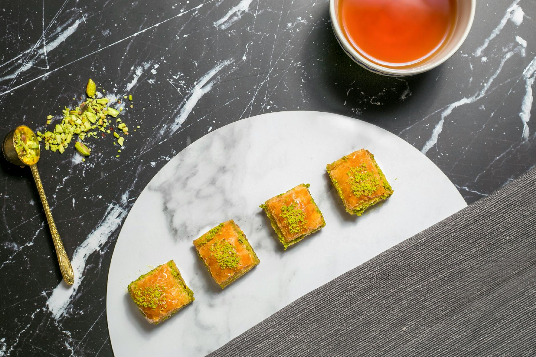 大理石のプレートに並べられたバクラヴァとトルコ紅茶のセット。