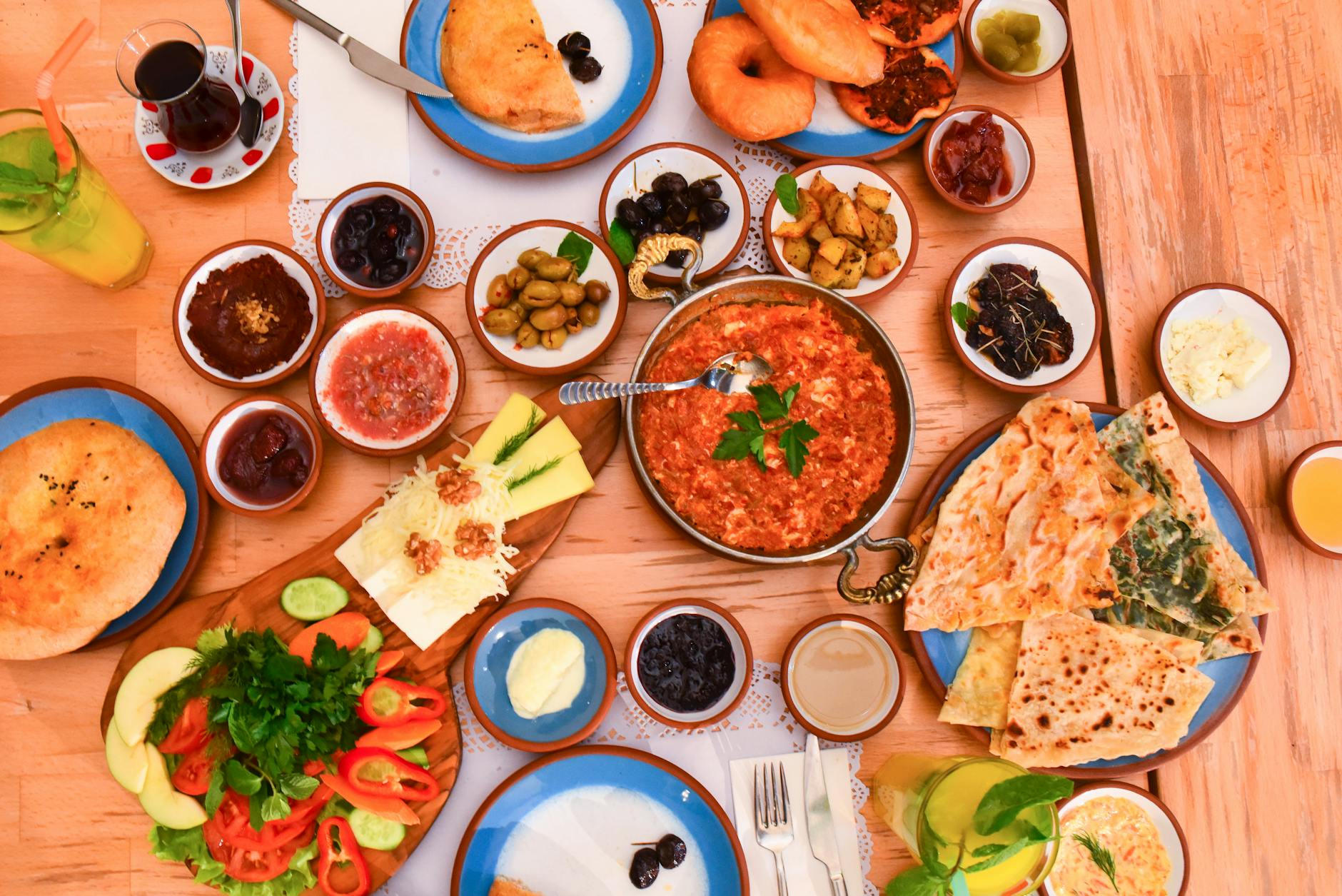 トルコの伝統的な朝食「エスナフ・ロカンタ」スタイルの豪華な食卓。シャクシュカ、チーズ、オリーブ、パン、新鮮な野菜などが並ぶ。